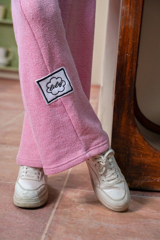 Pink fleece pants with a patch on a wooden floor