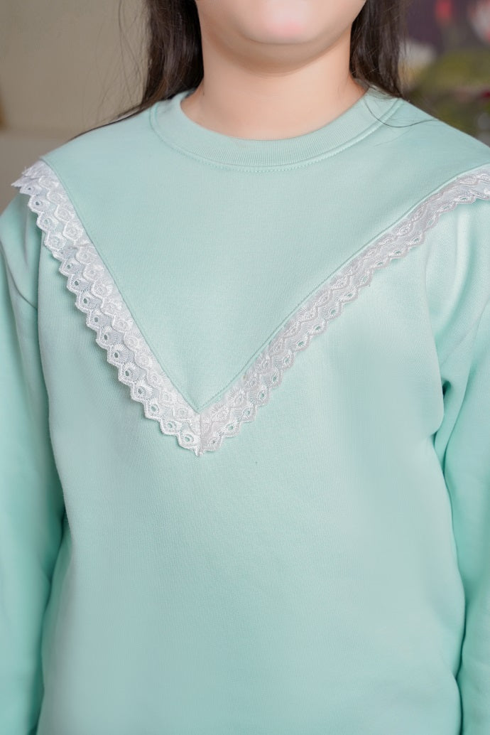 Light green top with white lace trim worn by a person