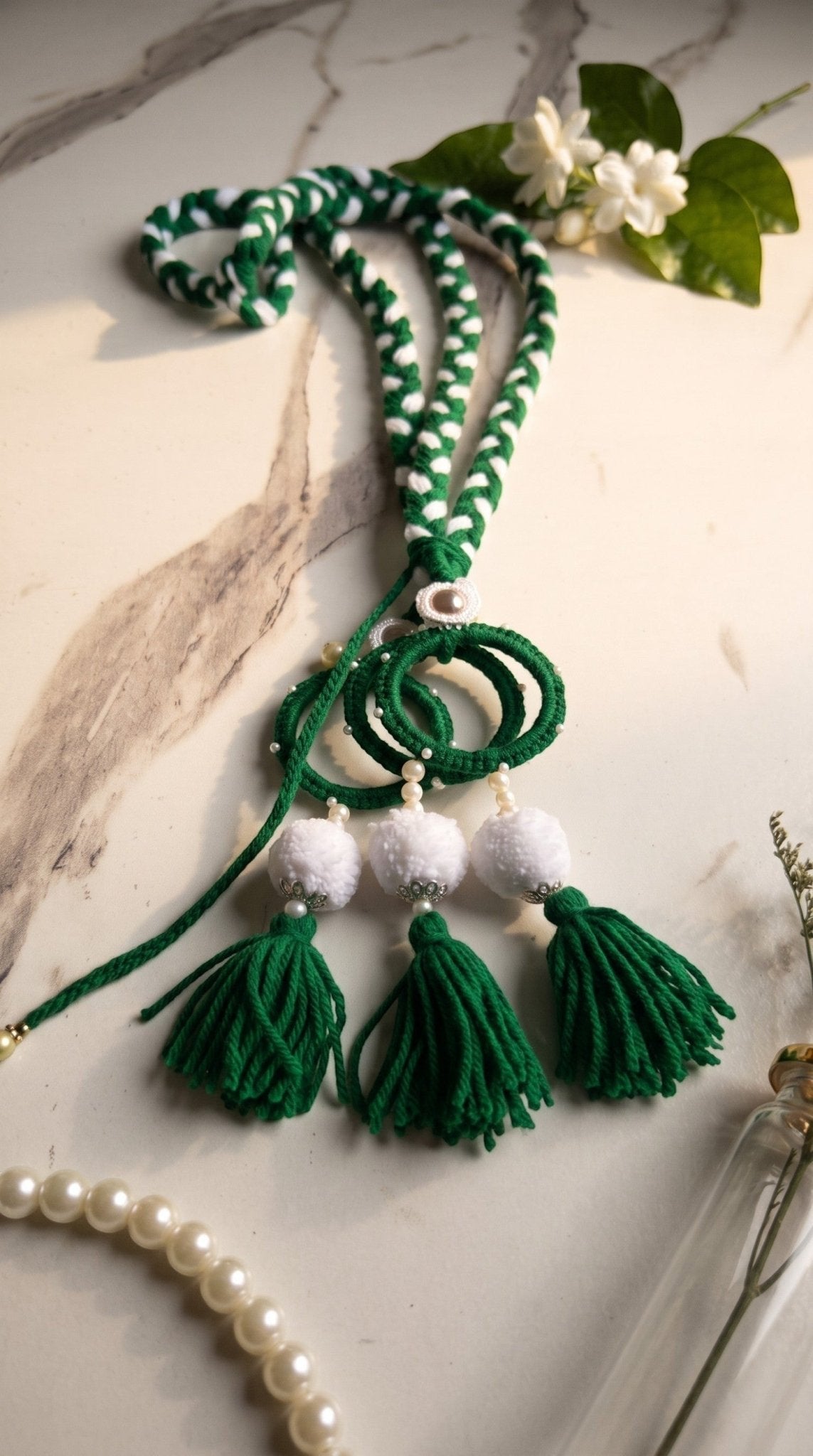 Lily Green Glory traditional paranda hair accessory with braided green and white threads, pom-poms, and tassels.