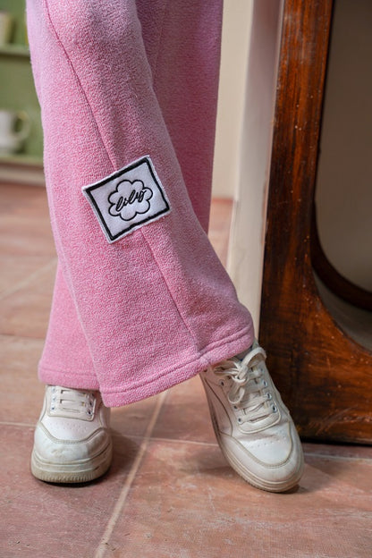 Pink fleece pants with a patch on a wooden floor