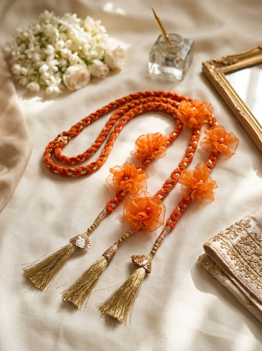 Lily Aamrass Blossom Paranda in vibrant orange with floral embellishments and gold-toned tassels for ethnic hairstyles.