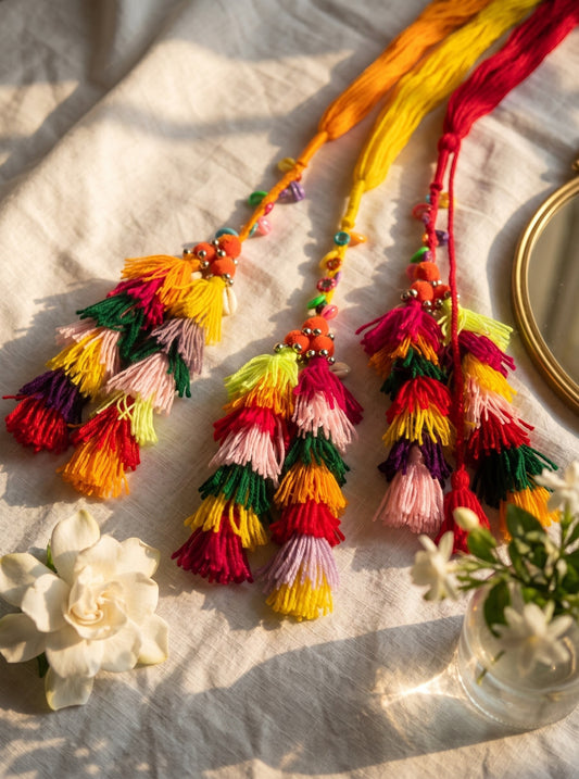 Lily Basanti Paranda hair accessory featuring vibrant multi-colored yarn tassels, intricate beads, and pom-pom accents.