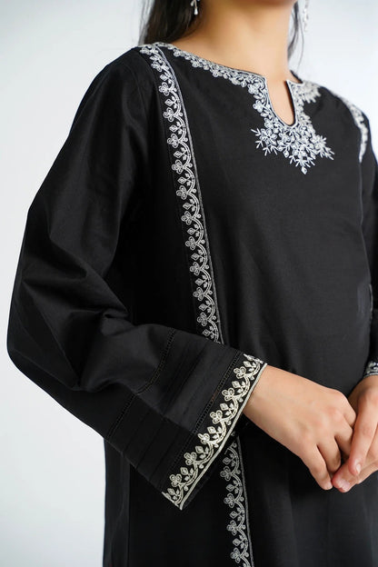 Lily black cotton kurta with white embroidery on neckline, sleeves, and hem. Features full sleeves and pleated cuffs.