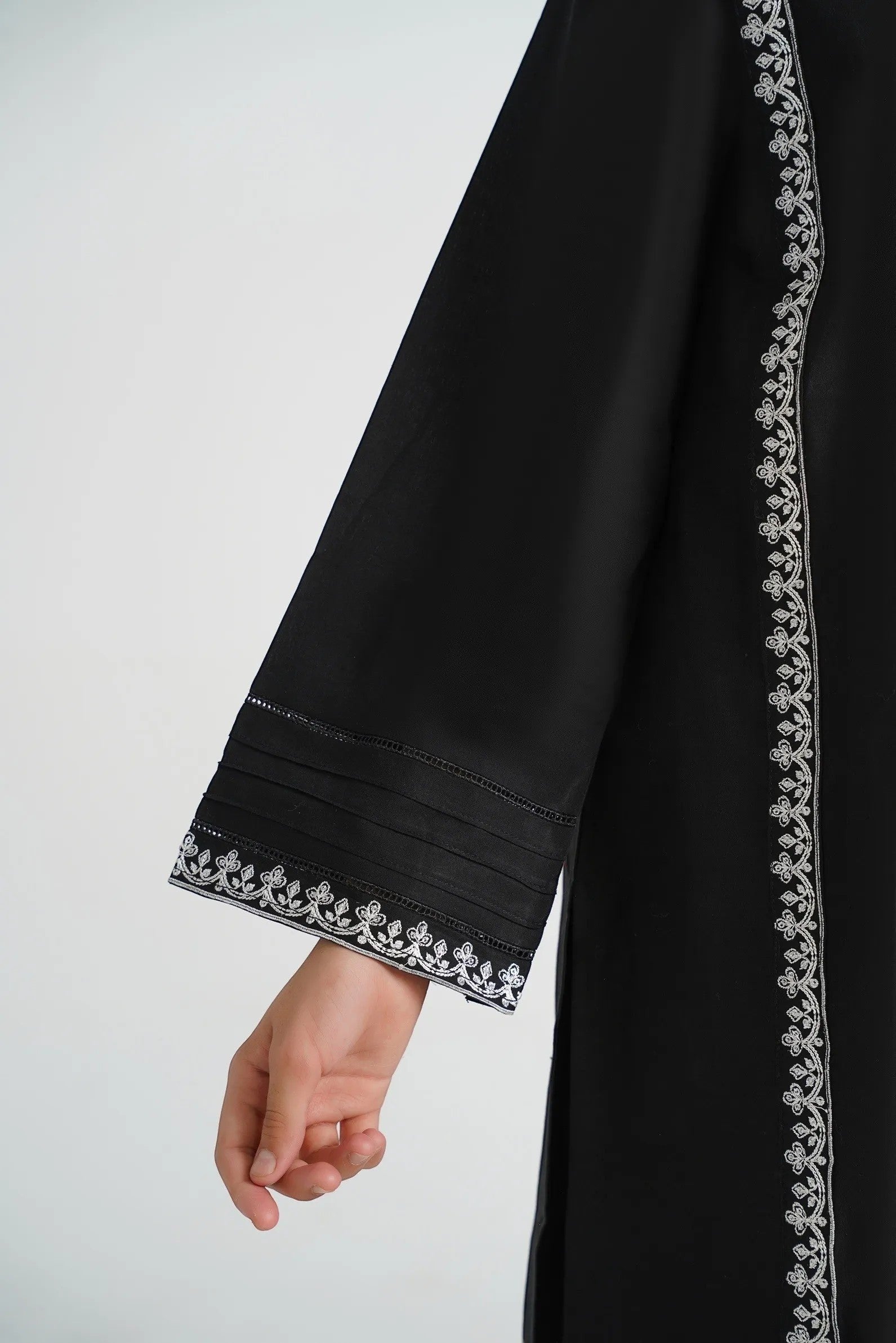 Lily black cotton kurta with white embroidery on neckline, sleeves, and hem. Features pleats and embroidered cuffs.
