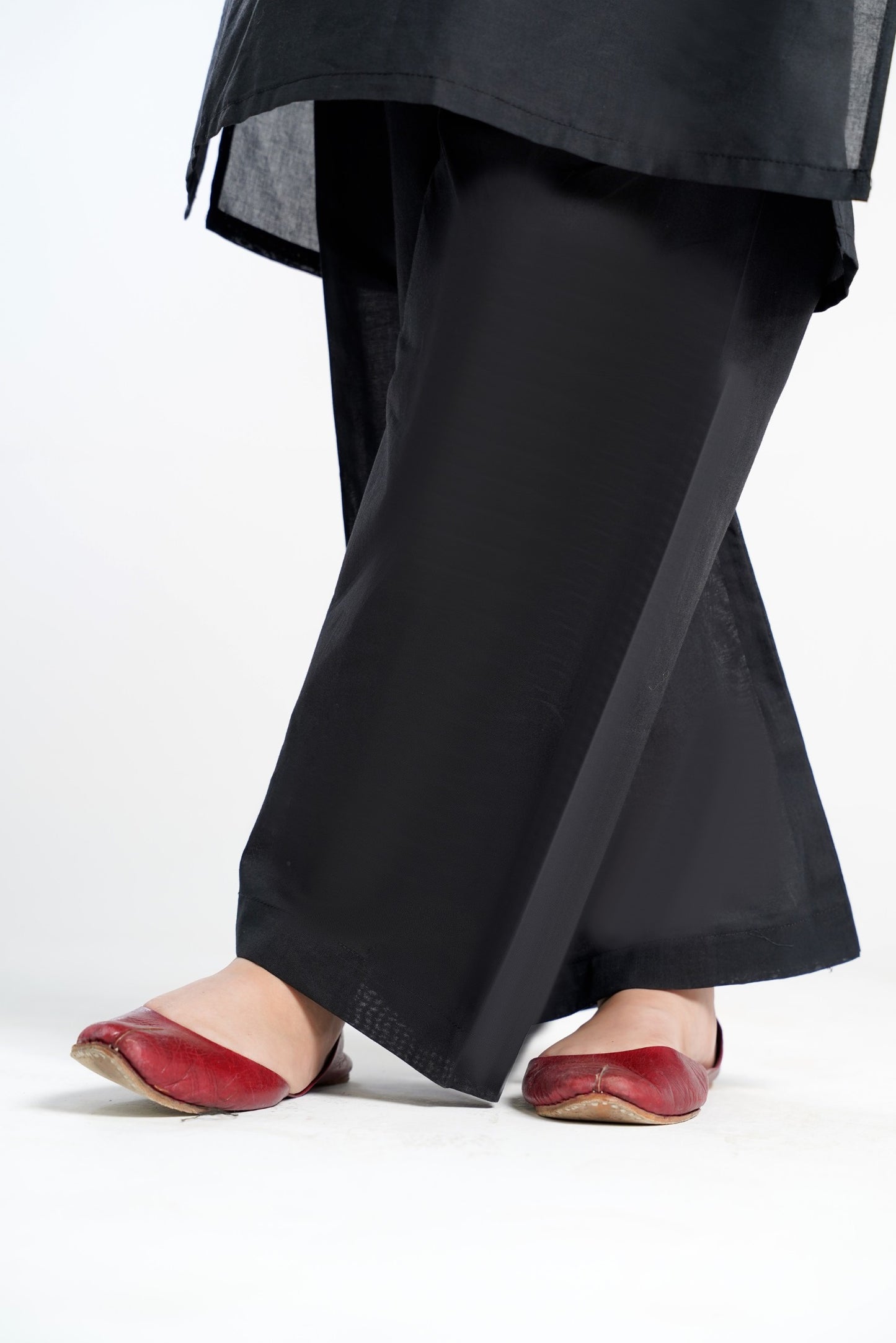 Lily black floral print kurti with pants, featuring flared sleeves and a relaxed fit. Paired with red flats.