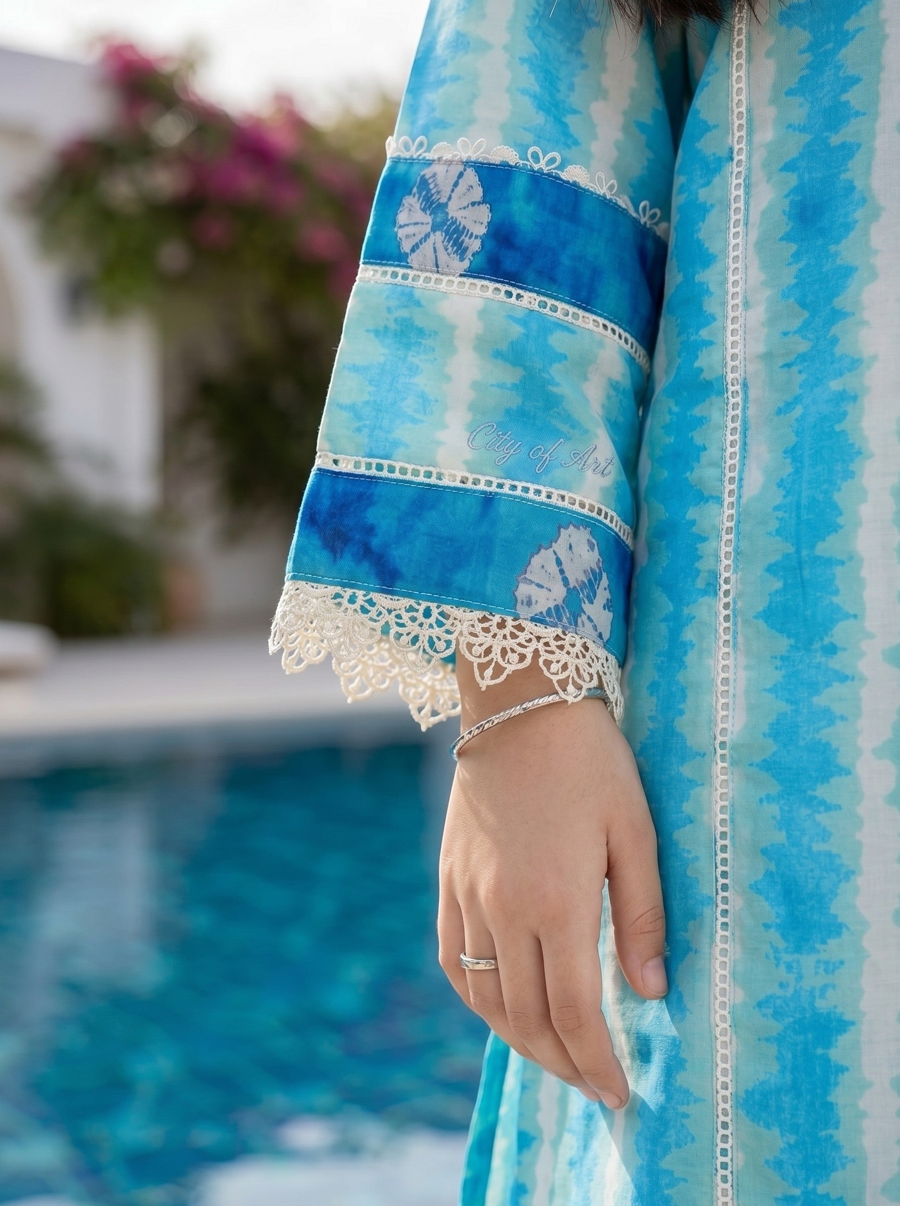 Lily girls blue and white tie-dye kurta sleeve with intricate lace trim and detailing by a swimming pool