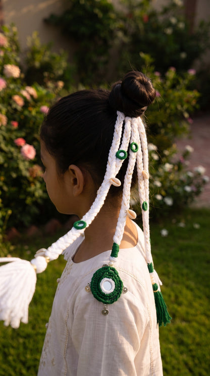 Lily Independence Elegance braided hair accessory with green and white cords, seashell accents, and mirror details.