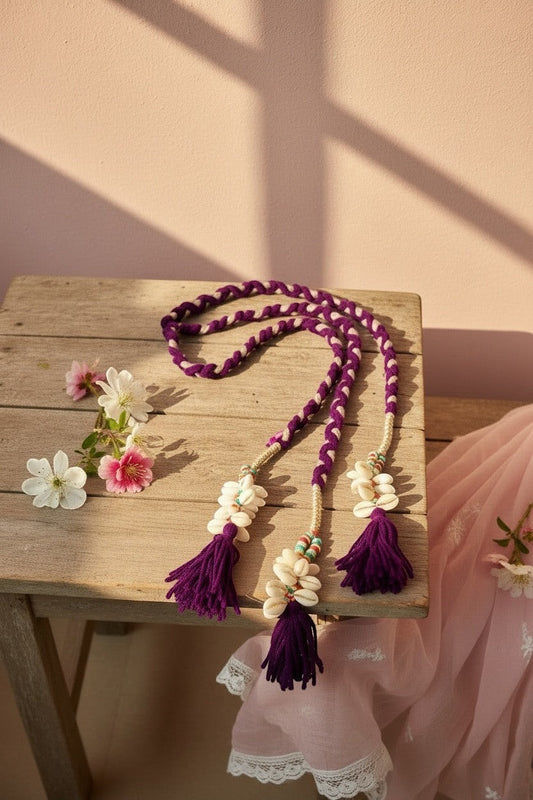 Lily braided purple and white cord hair accessory with shells, tassels, and beads. Bohemian style.