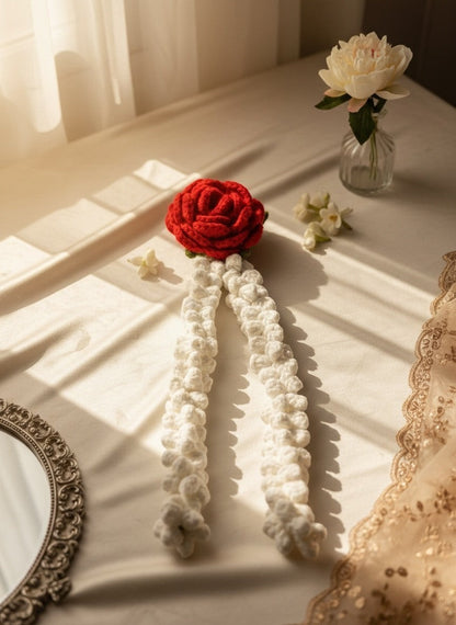 Lily handmade crochet hair accessory featuring a vibrant red rose and cream jasmine strands for a bohemian look.