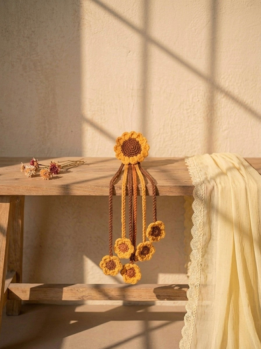 Lily handcrafted crochet hair accessory with sunflower motif and dangling floral accents in yellow and brown.