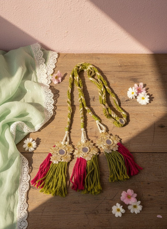 Lily embellished green and gold braided hair accessory with floral embellishments, mirrors, and fuchsia and green tassels.