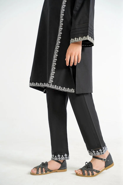 Lily black cotton kurta with white embroidery on neckline, sleeves, and hem, paired with black pants.