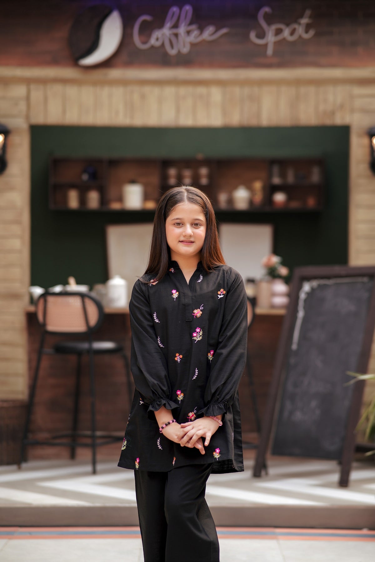 Lily girls black tunic and trouser set with multi-colored floral embroidery, long sleeves, and ruffled cuffs