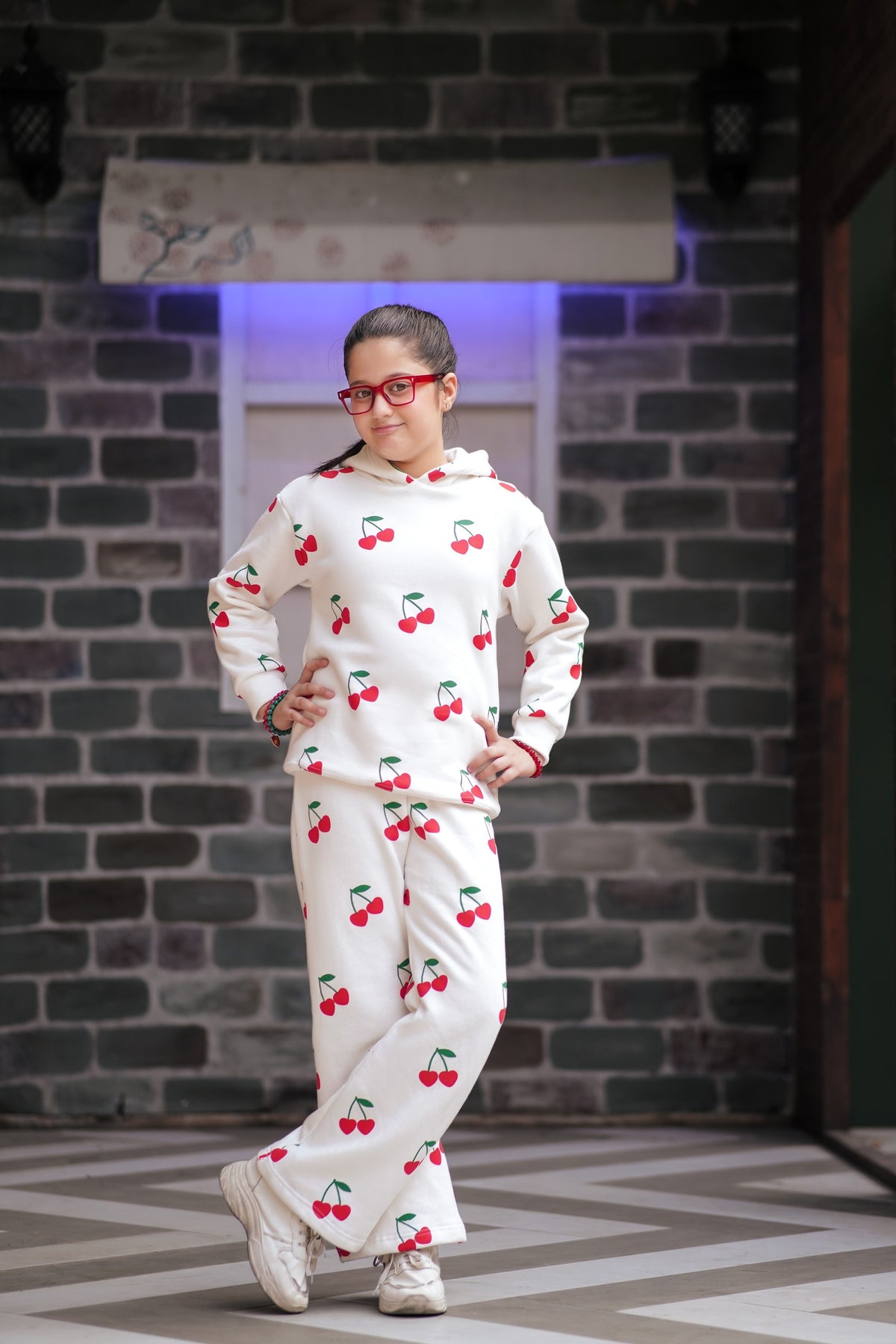 Lily girls white loungewear set with red cherry print, featuring a hooded sweatshirt and wide-leg pants on a girl.