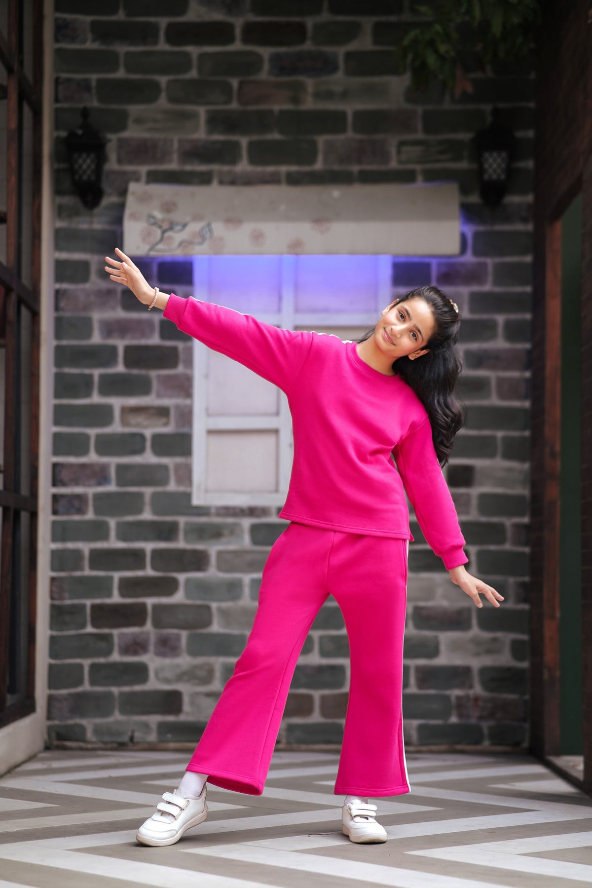 Lily girls hot pink two-piece tracksuit with crew-neck sweatshirt and wide-leg trousers featuring white side stripes.