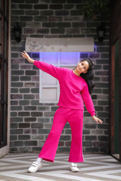Lily girls hot pink two-piece tracksuit with crew-neck sweatshirt and wide-leg trousers featuring white side stripes.