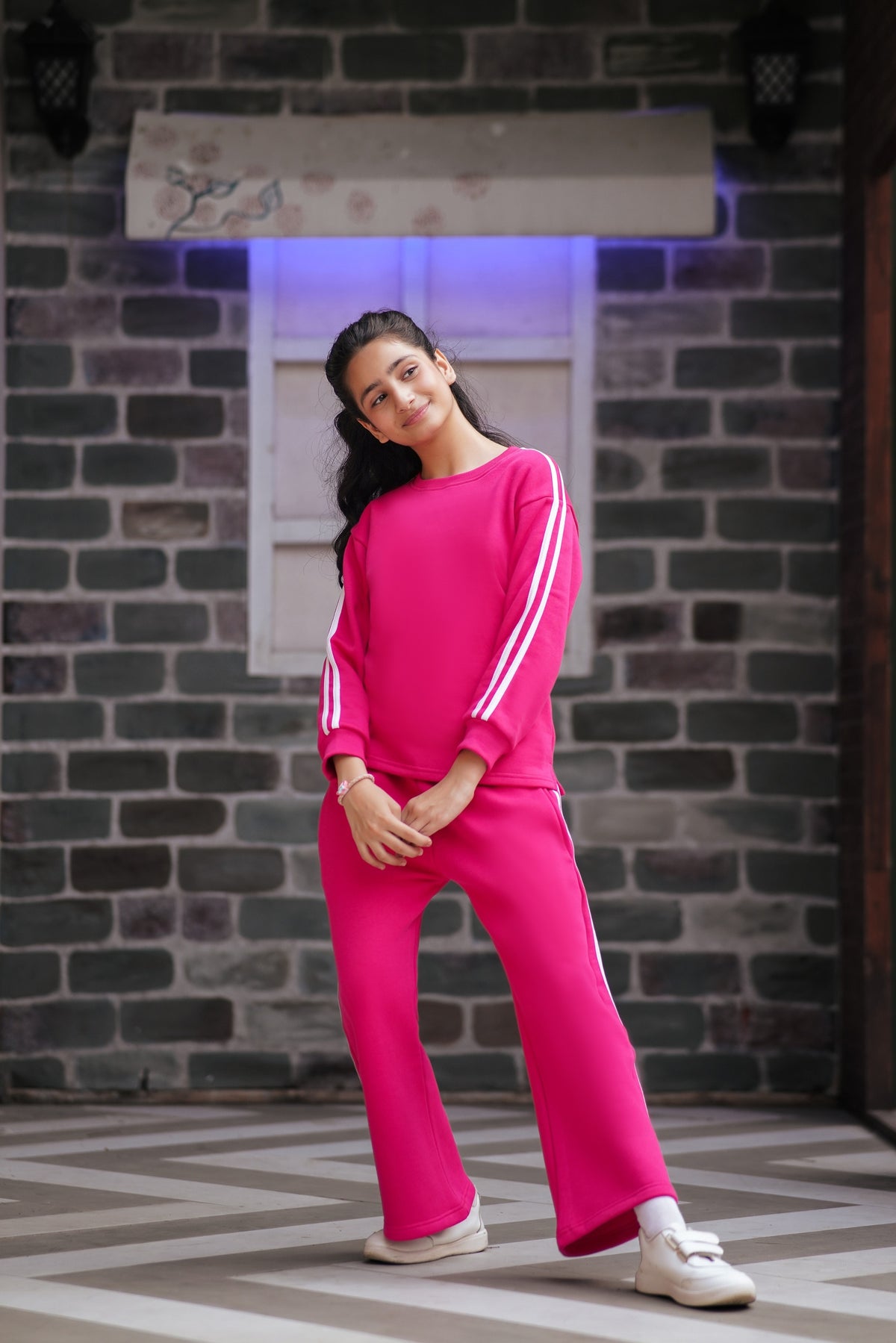 Lily girls hot pink two-piece tracksuit with white side stripes, crew-neck sweatshirt, and wide-leg trousers.