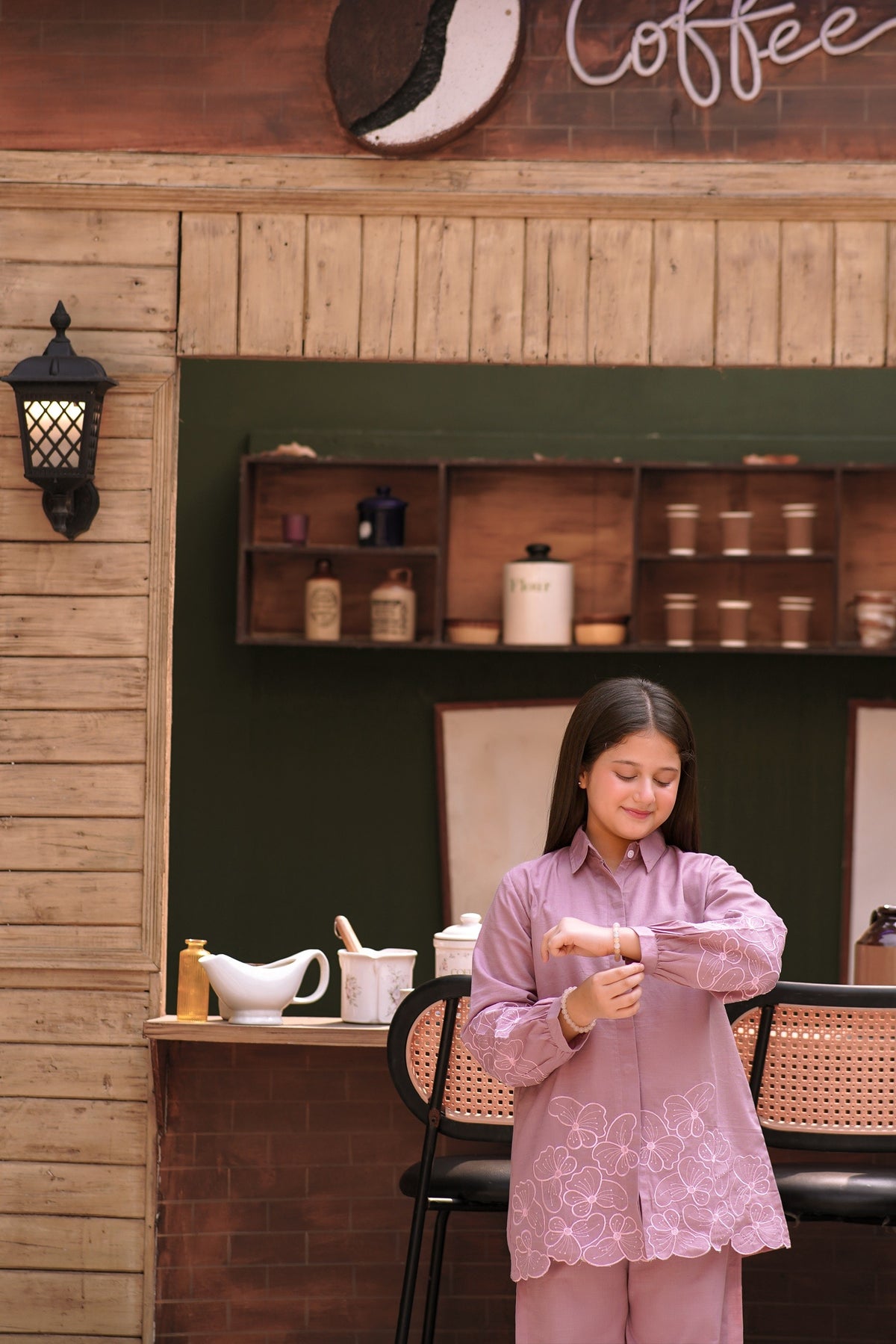 Lily girls mauve button-down shirt and trouser set with delicate floral embroidery in a cozy cafe setting