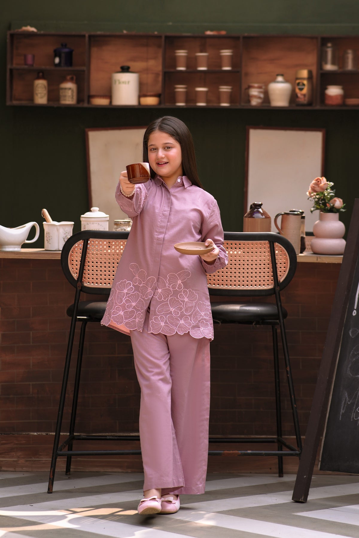 Lily girls mauve button-down shirt and trouser set with delicate floral embroidery, worn by a girl holding a cup.