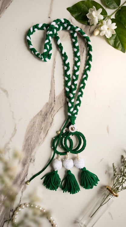 Lily Green Glory traditional braided paranda hair accessory with white pom-poms and green tassels on a marble surface.