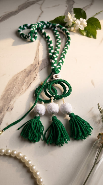Lily Green Glory traditional paranda hair accessory with braided green and white threads, pom-poms, and tassels.