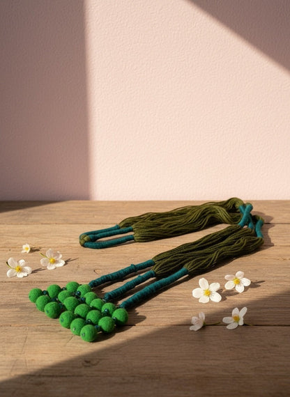 Lily handcrafted green pom pom necklace with braided teal and deep green cord. Artisanal ethnic jewelry.