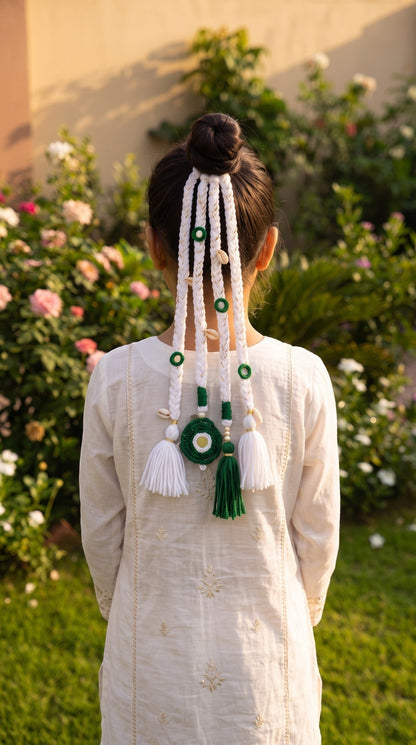 Lily Independence Elegance Braids hair accessory with green and white cords, seashells, and tassels on a high bun.