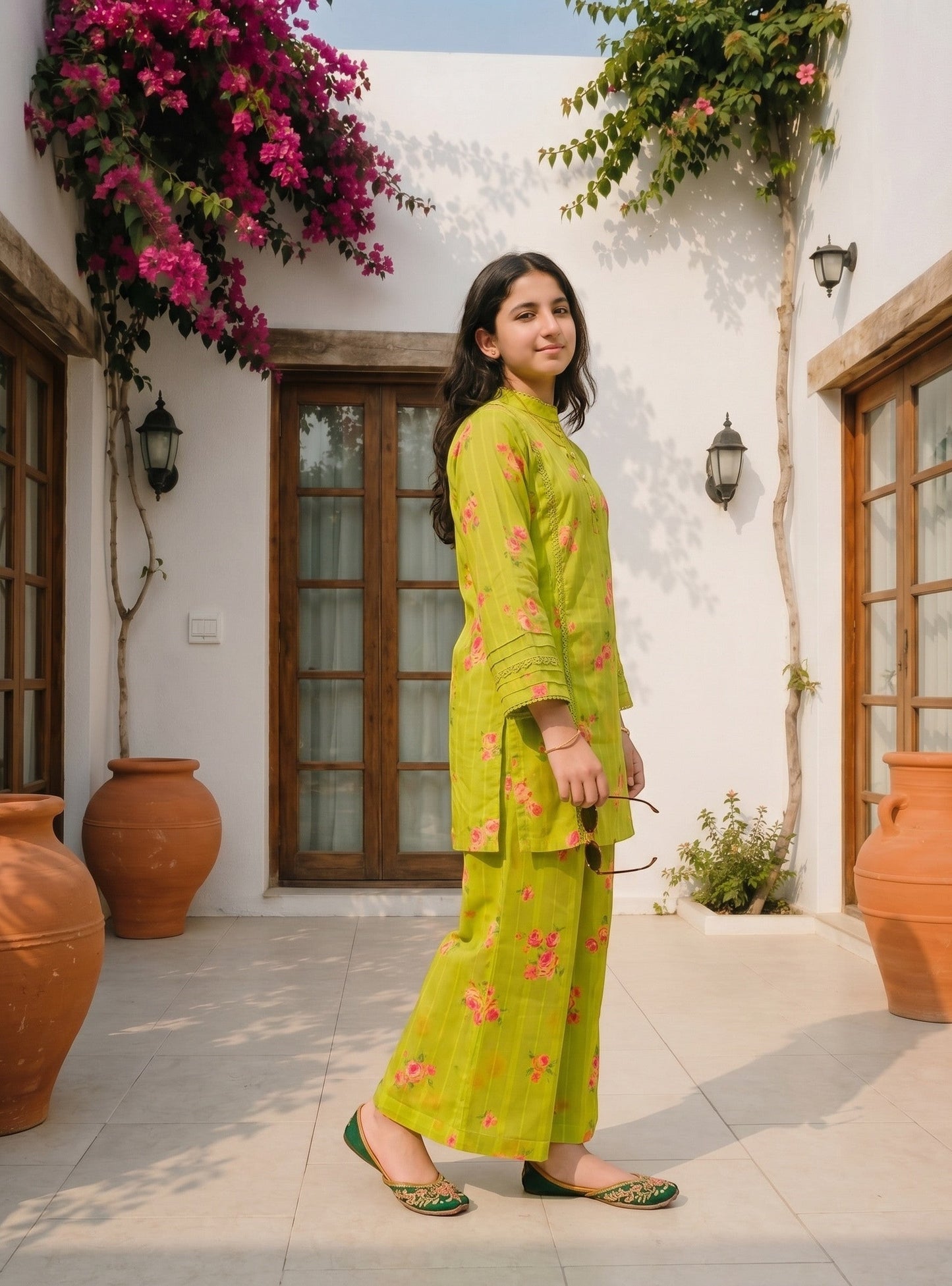 Lily lime green floral kurta set with lace details and wide-leg trousers worn by a woman in a sunny courtyard.