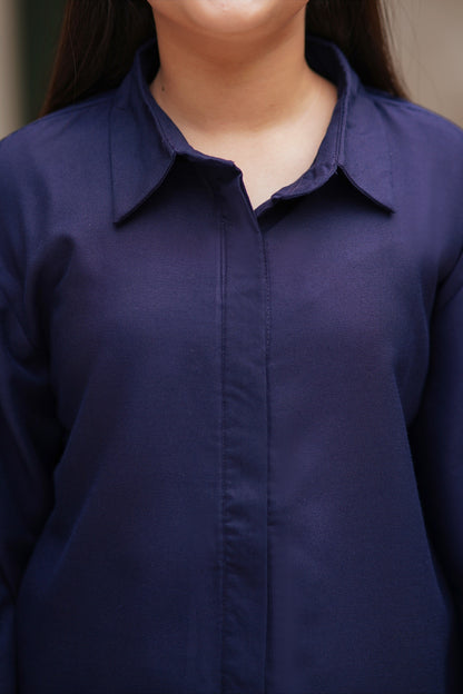 Lily navy blue long sleeve button down tunic with a classic collared neckline worn by a young girl