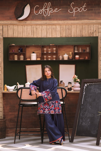 Lily navy blue two-piece kurta set with multi-colored geometric embroidery on a young girl in a cafe setting