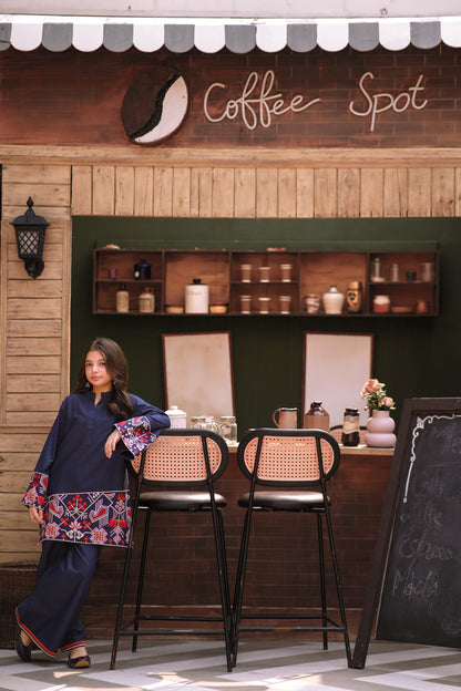 Lily navy blue two-piece kurta set with geometric embroidery on sleeves and hem worn by a girl in a cafe setting