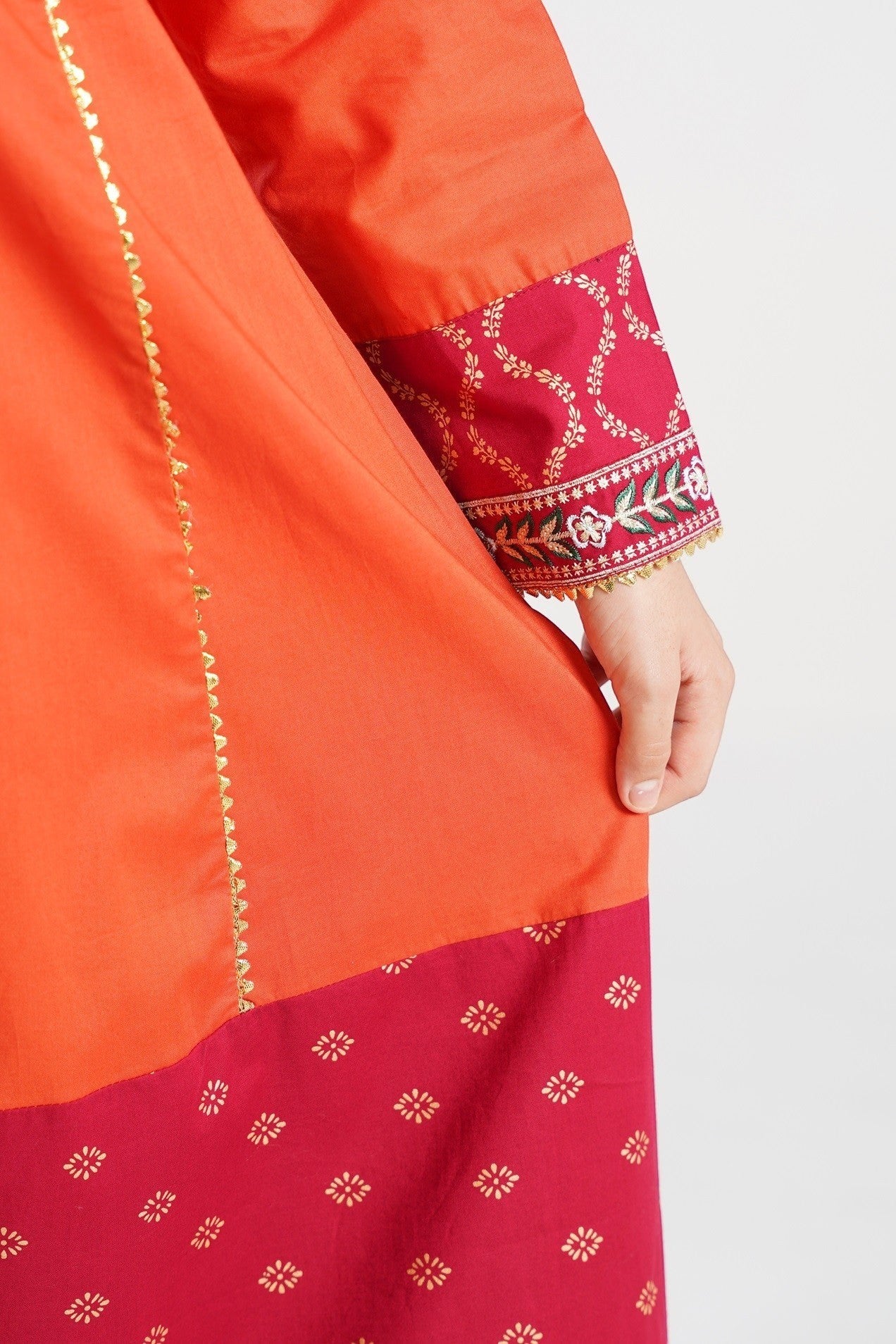 Lily orange embroidered kurta with maroon panels and gold print, paired with matching pants and dupatta.