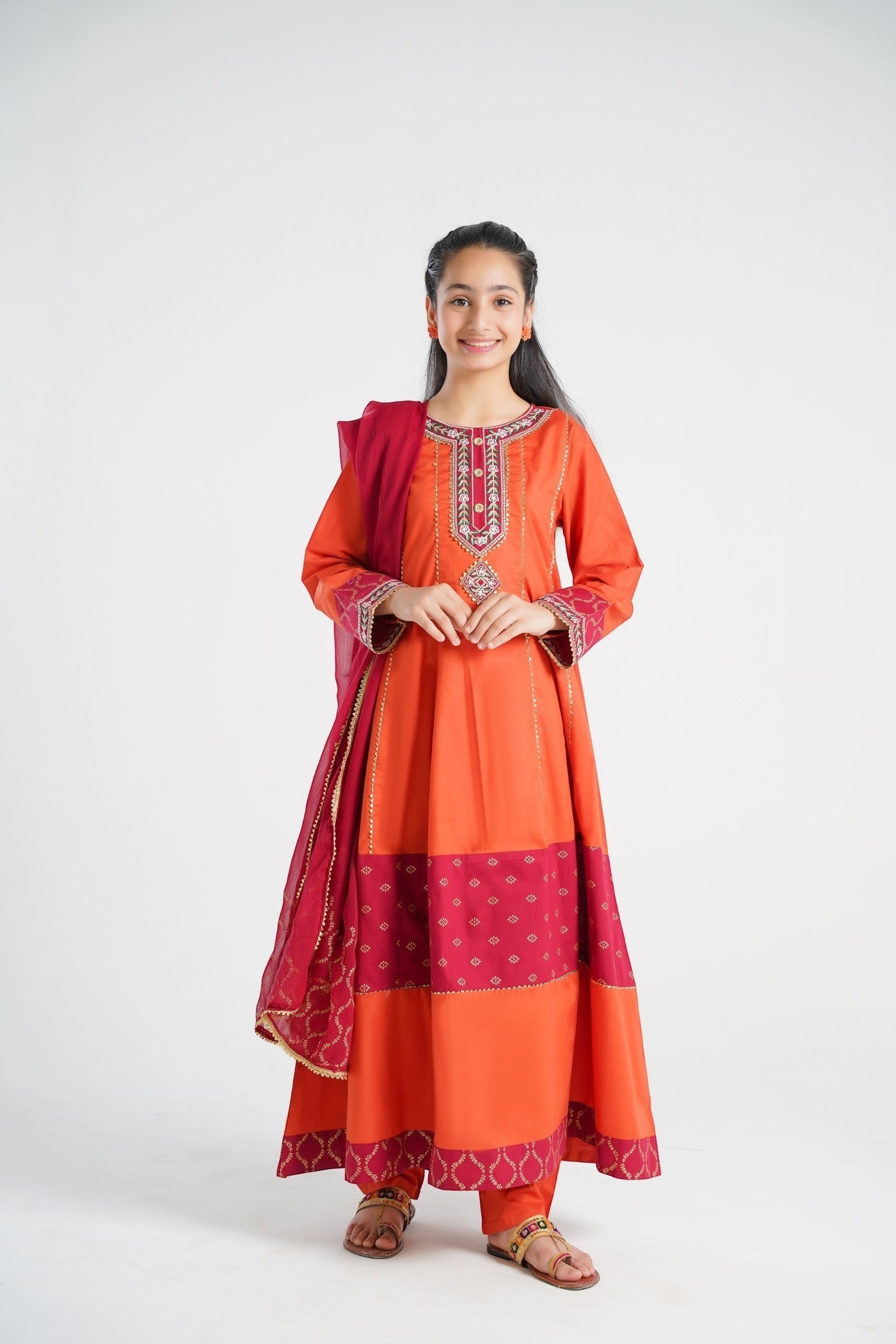 Lily orange embroidered kurta set for girls with pants and dupatta. Features gold print and maroon panels.