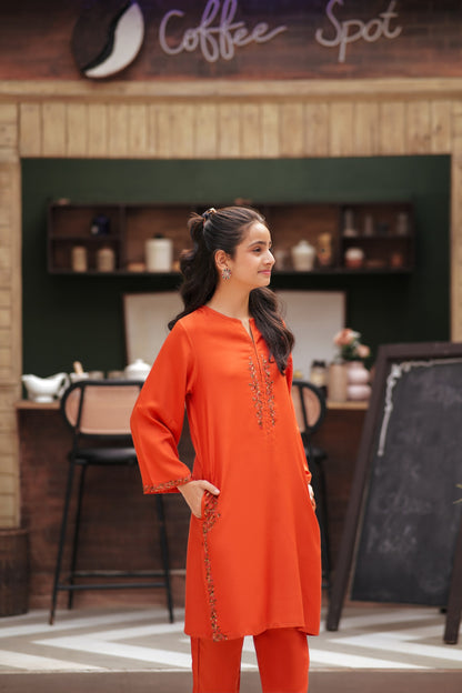 Lily orange embroidered kurta and trouser set with floral detailing on the neckline and side slits in a cafe setting