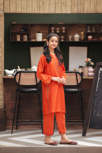 Lily orange embroidered kurta and trouser set worn by a girl in a cafe setting with floral detailing and side pockets