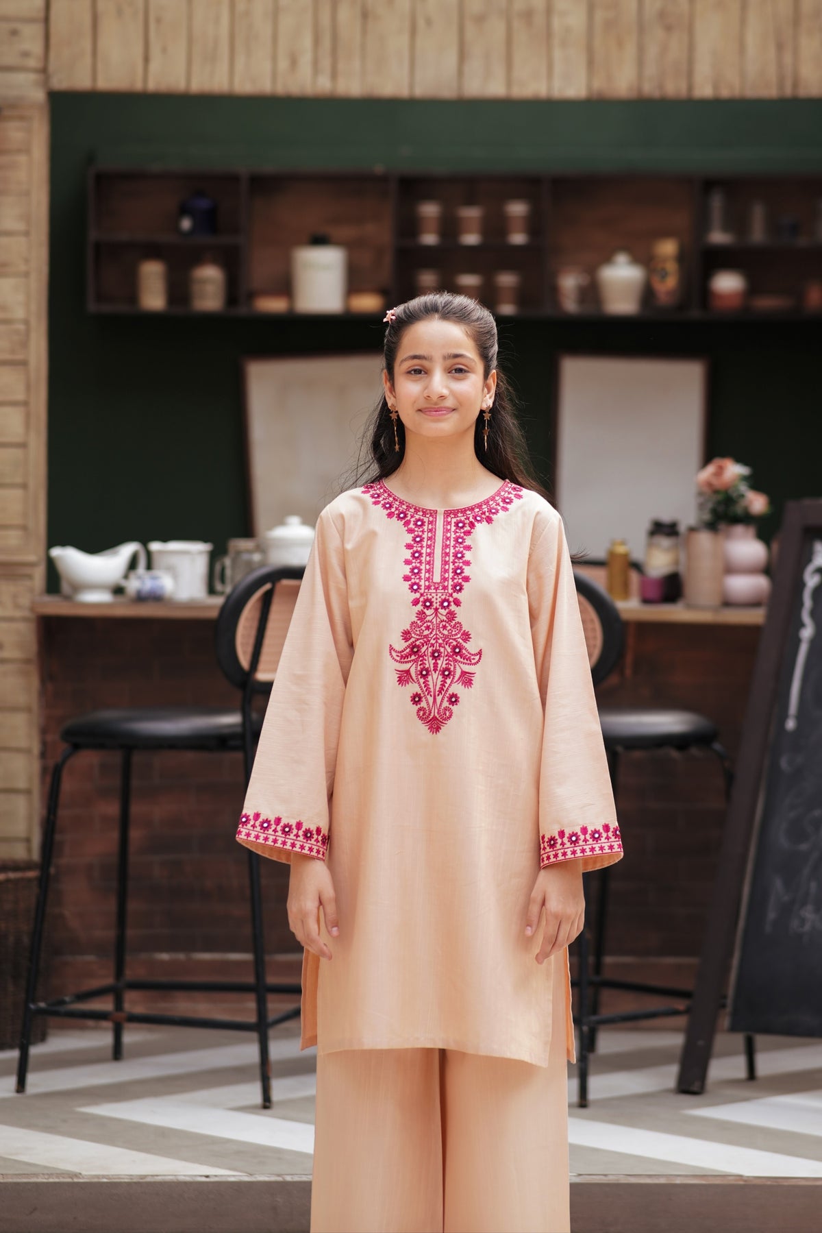 Lily girls peach kurta and trouser set with vibrant magenta floral embroidery and mirror work on neckline and cuffs