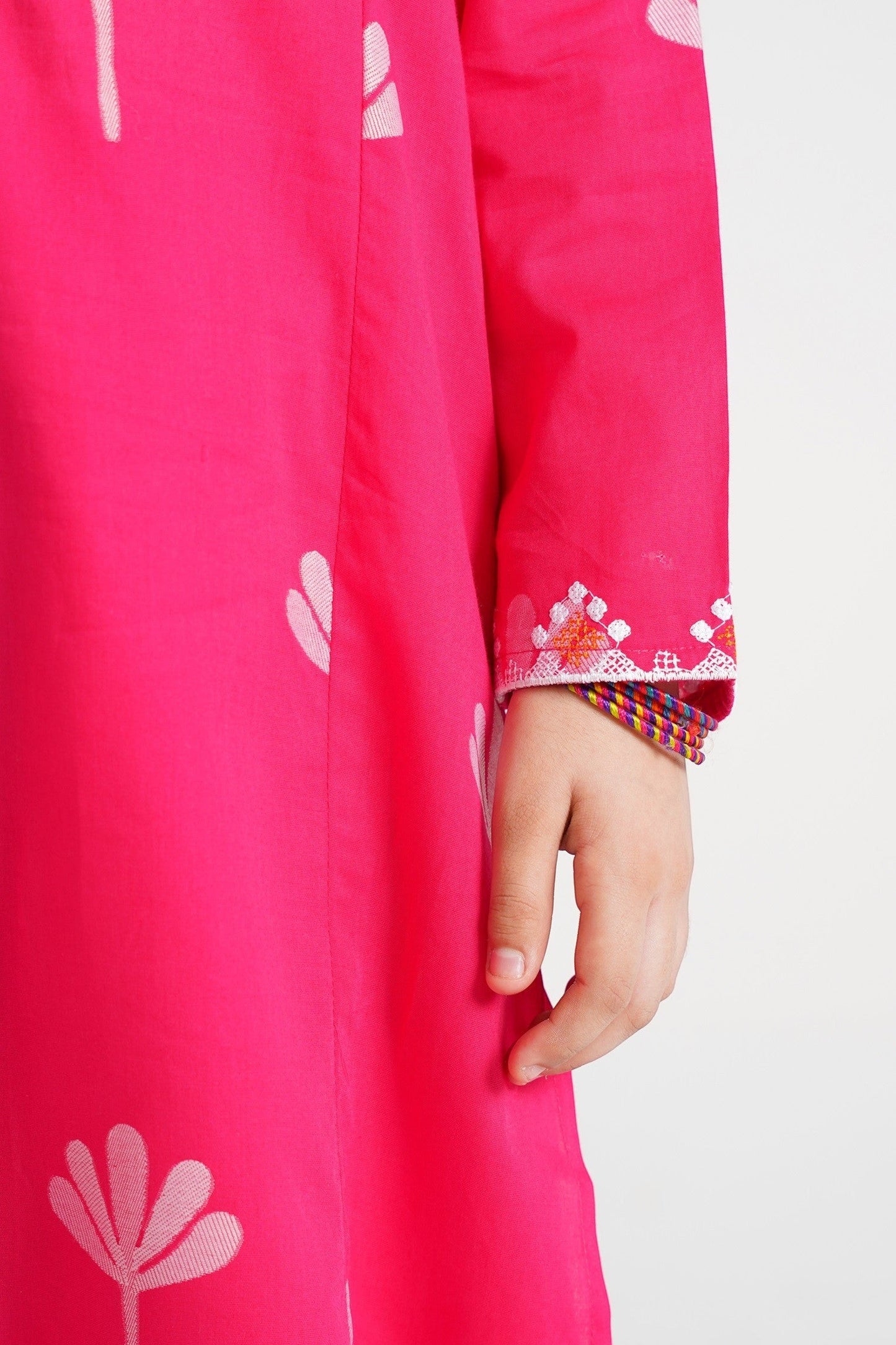Lily pink cotton kurta with floral print and embroidered cuffs, worn by a child.