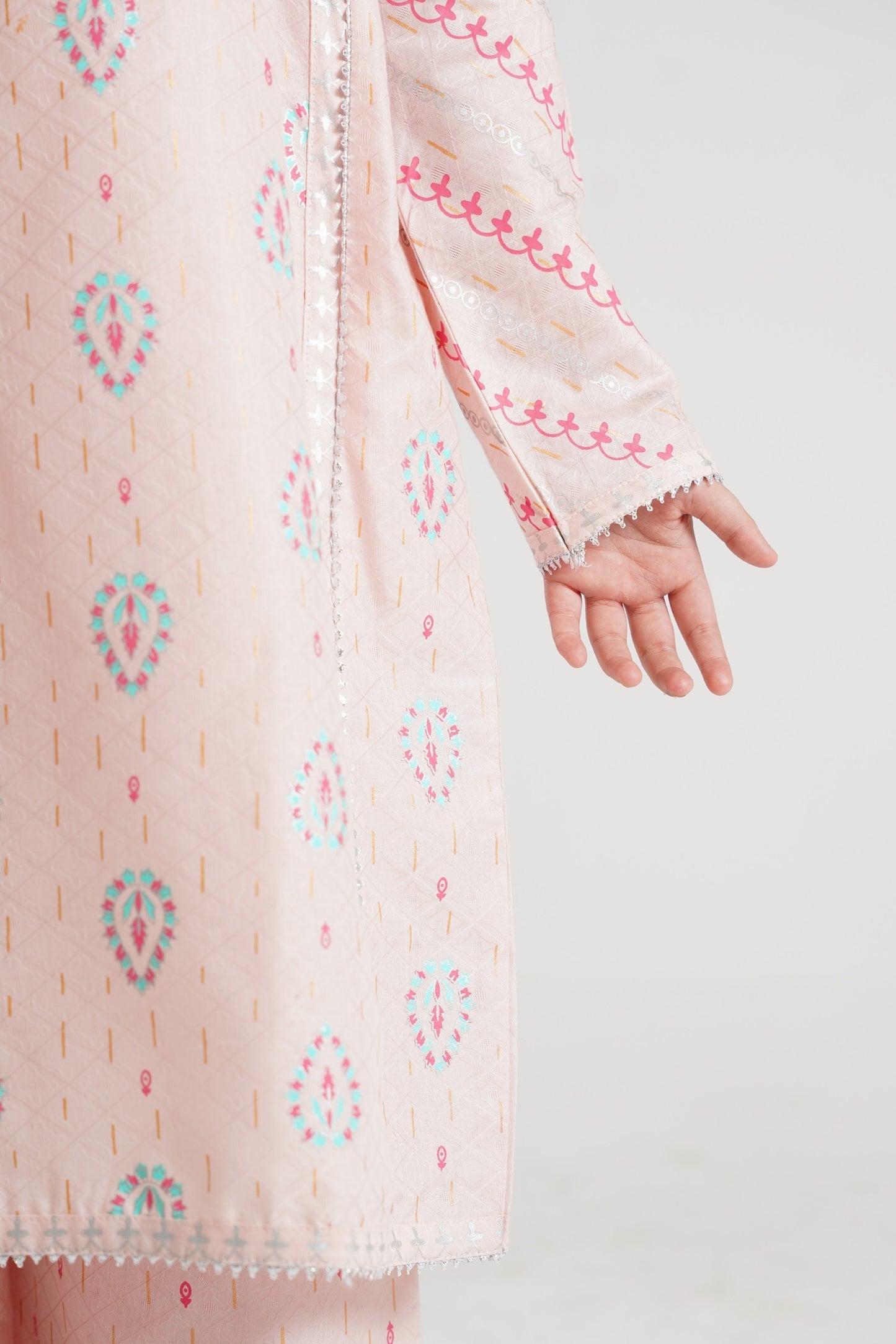 Lily pink embroidered tunic with teal and gold print, V-neck, silver trim, and tassels, paired with palazzo pants.