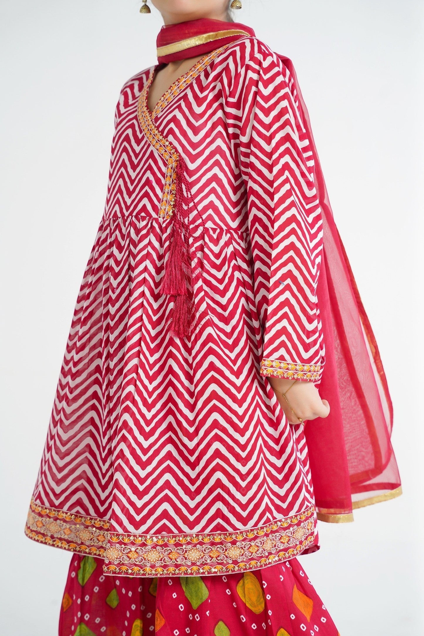 Lily red and white chevron print angrakha kurta with embroidery and tassels, paired with red gharara pants and dupatta.