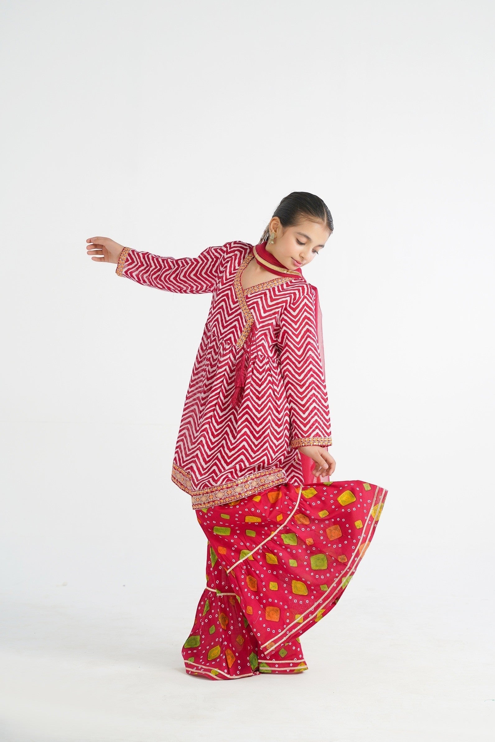 Lily red and white chevron angrakha kurta with embroidered border and tassels, paired with printed gharara pants and dupatta.