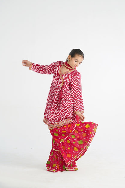 Lily red and white chevron angrakha kurta with embroidered border and tassels, paired with printed gharara pants and dupatta.