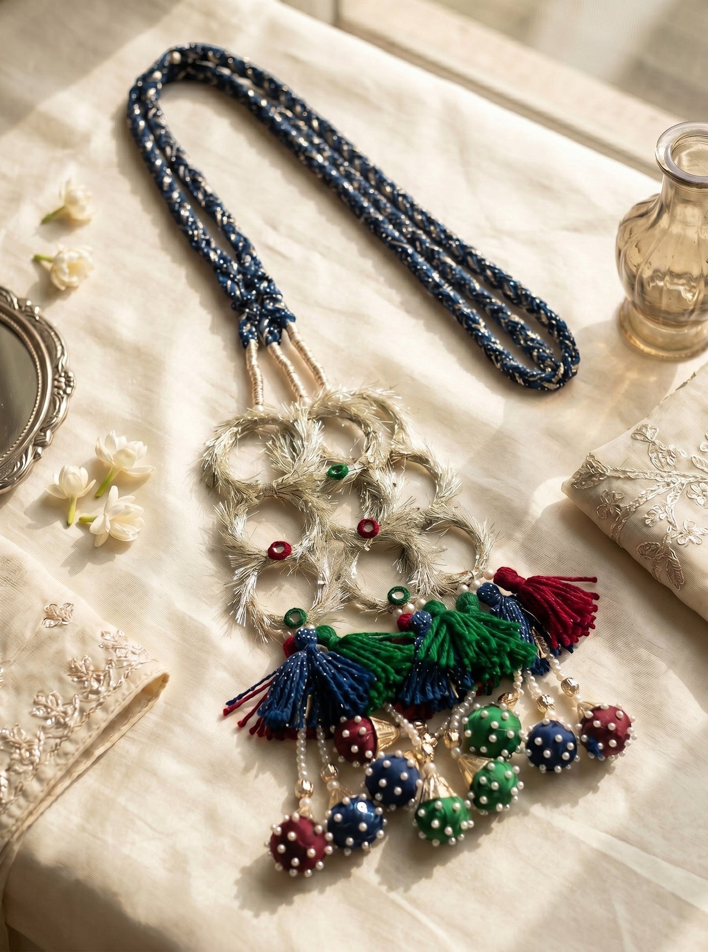 Lily Ruby Heer Paranda featuring a blue braided cord, silver mirror-work accents, and multi-colored tassel pom-poms.