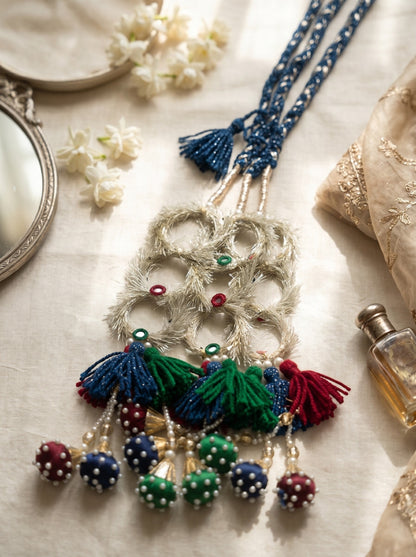 Lily Ruby Heer Paranda featuring a blue braided cord, silver mirror-work accents, and colorful tassels with pearl pom-poms.