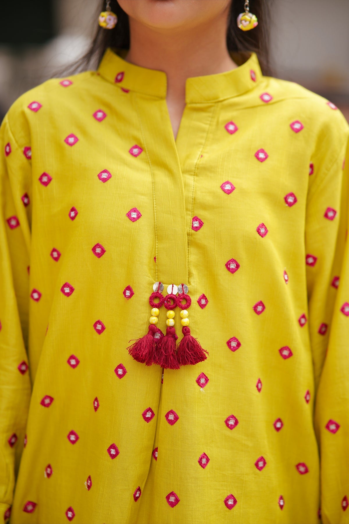 Lily girls yellow kurta with pink geometric embroidery, mandarin collar, and decorative red tassel detail