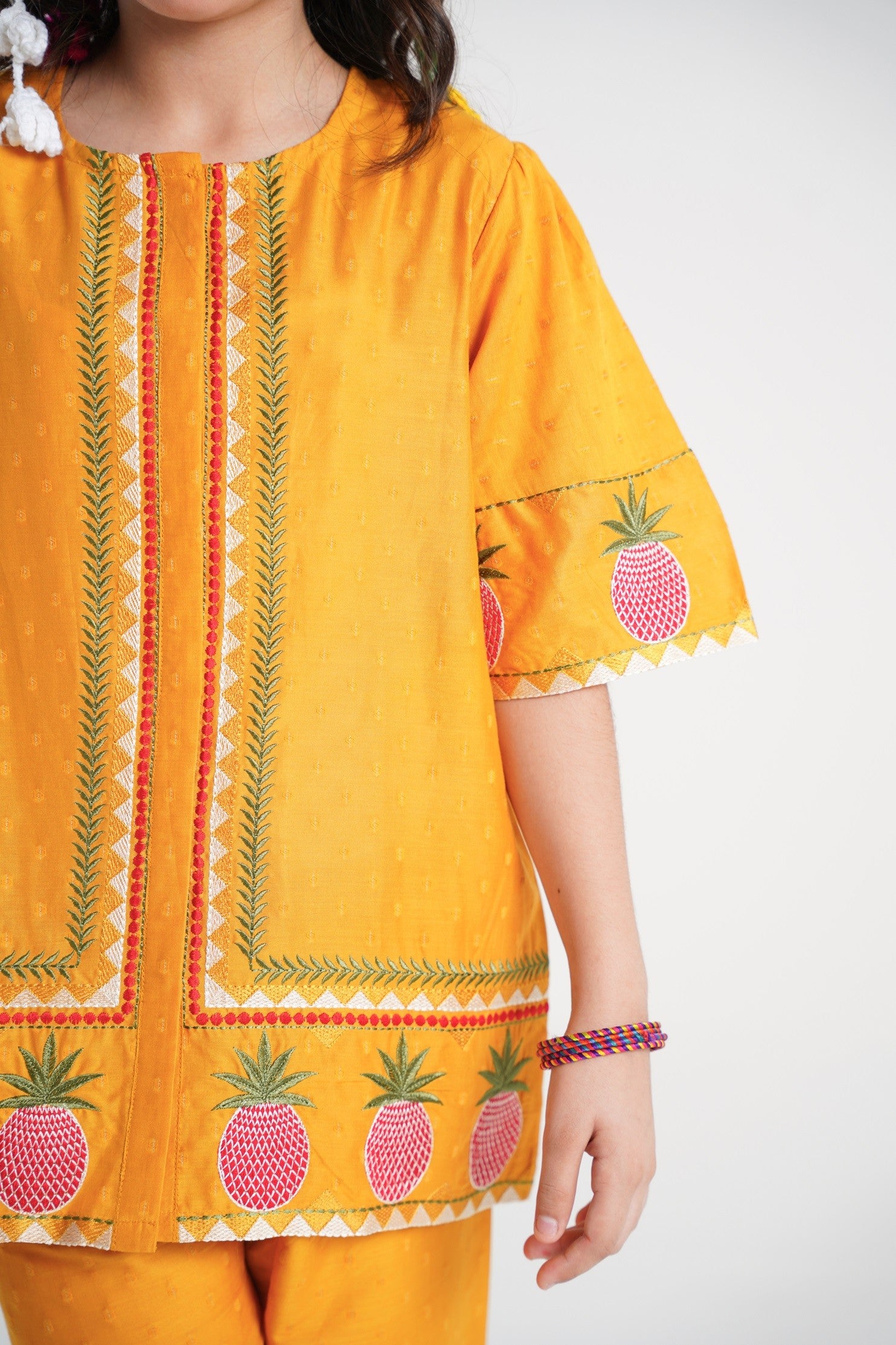 Lily yellow textured kurta and pants set with pineapple embroidery on sleeves and hem, featuring green and red trim.