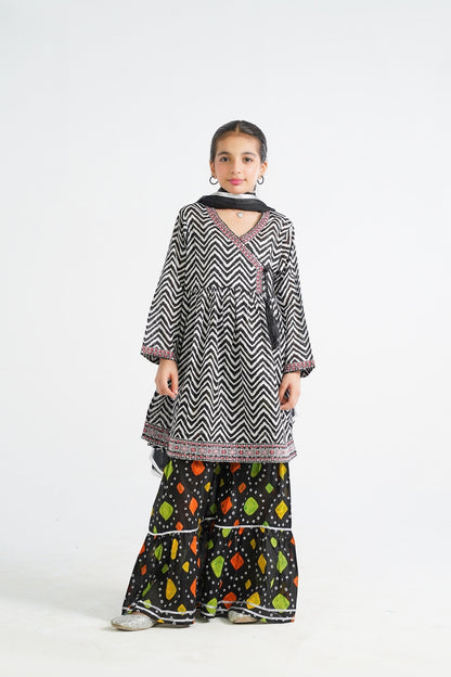 Lily black and white zigzag print kurta with red embroidery and tassels, paired with colorful tiered sharara and dupatta.